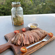 Load image into Gallery viewer, Smoked Pork Tenderloin sliced on board with Puerto Galera hills backdrop
